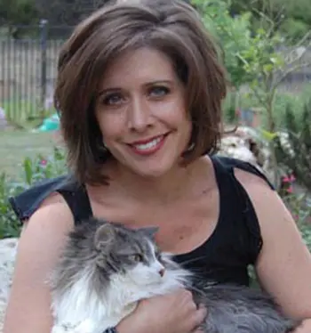 A woman holding a cat in her arms.