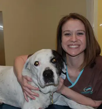 A woman holding a dog in her arms.