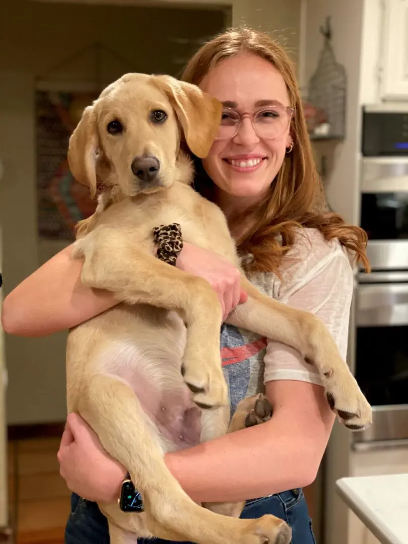 A woman holding a dog in her arms.