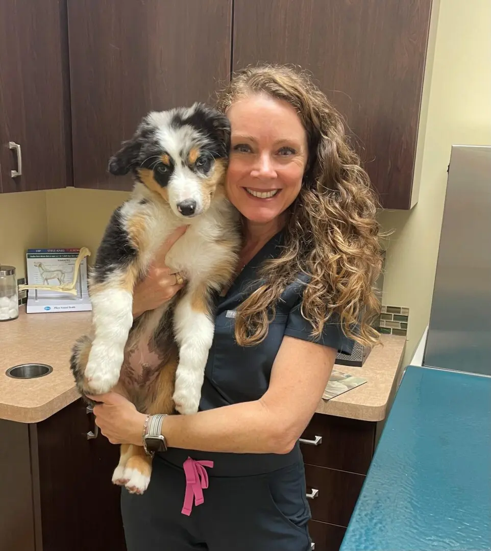 A woman holding a dog in her arms.