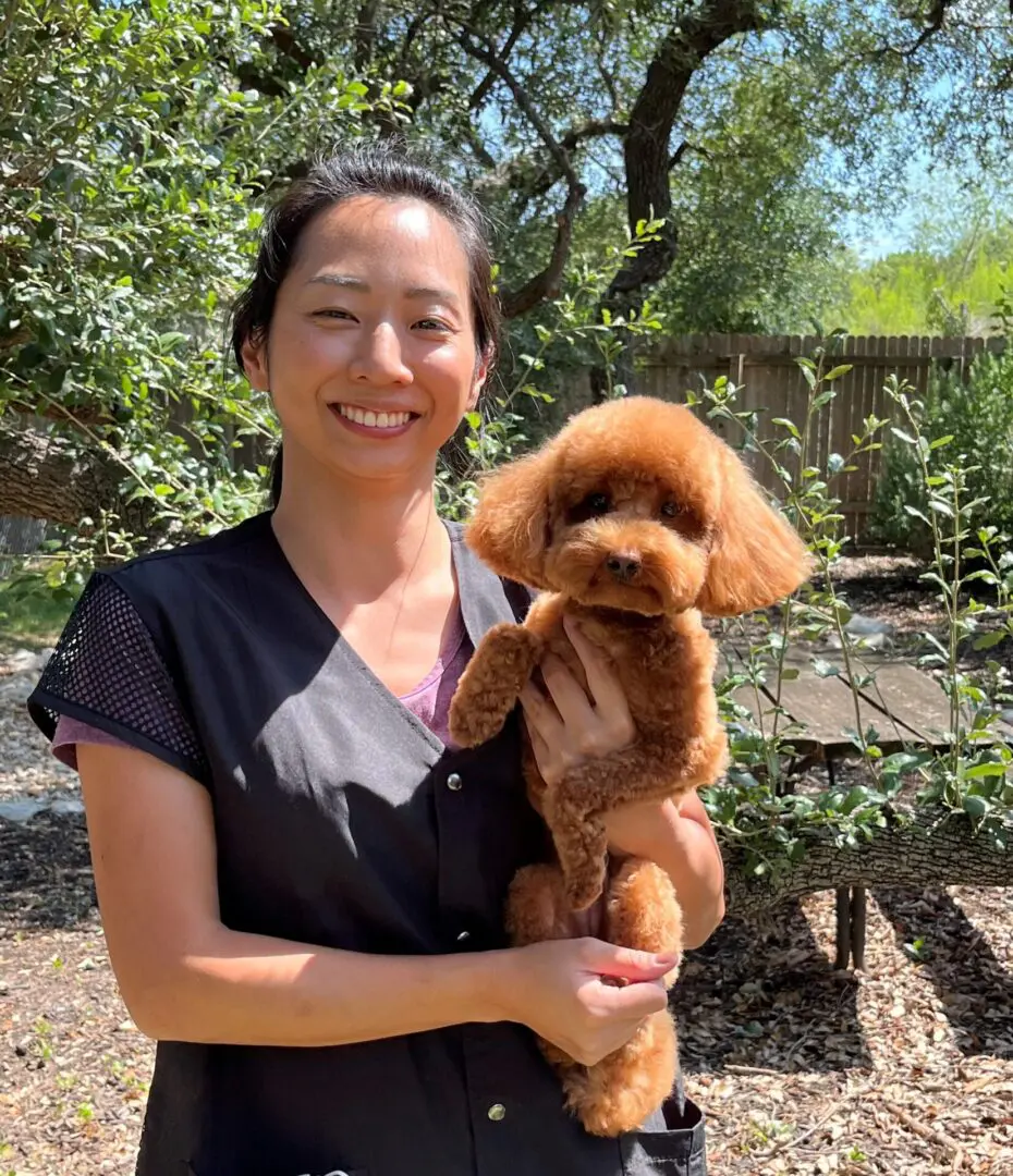 A woman holding a dog in her arms.