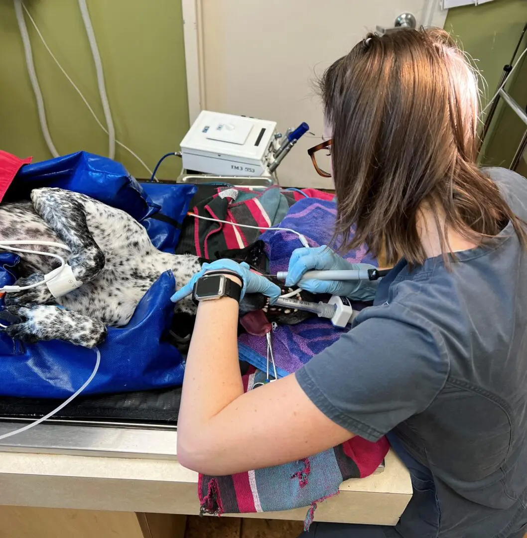 A woman ironing clothes on top of a table.