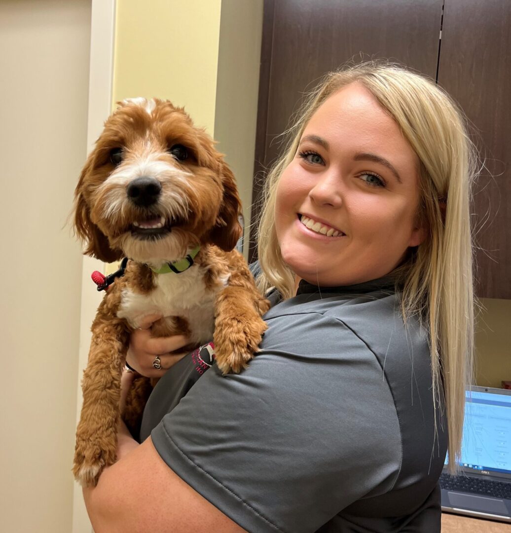 A woman holding a dog in her arms.