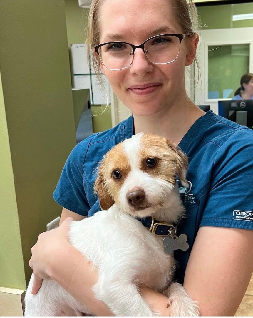 A woman holding a small dog in her arms.